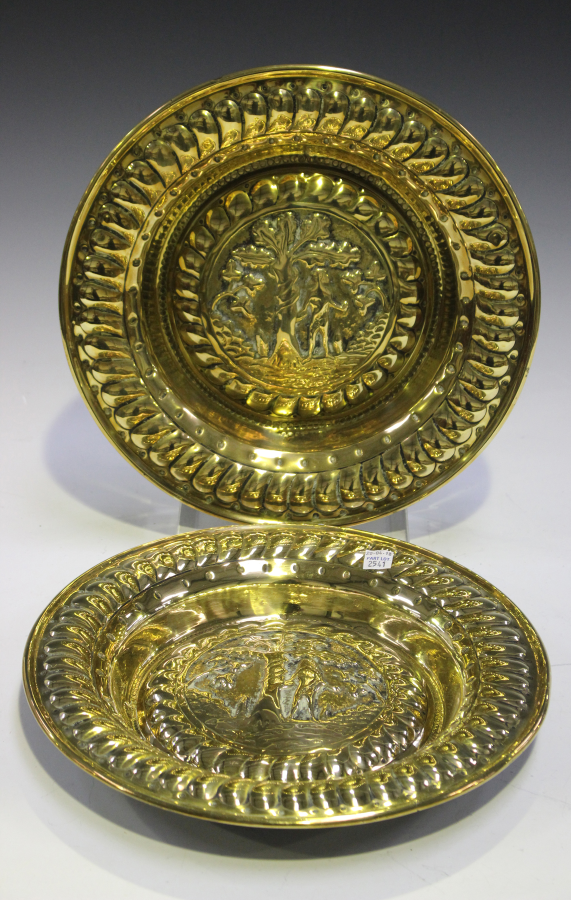 A pair of early 19th century Nuremberg style brass alms dishes, each decorated with Eve standing