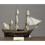 A partial kit built wooden model of H.M.S. Bounty, with perspex hull to one side to show the