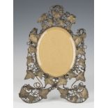 A late Victorian wrought and pressed brass photograph frame, the bevelled glass plate within a