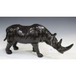 An early 20th century lacquered leather figure of a rhinoceros, length 54.5cm, a plated three-