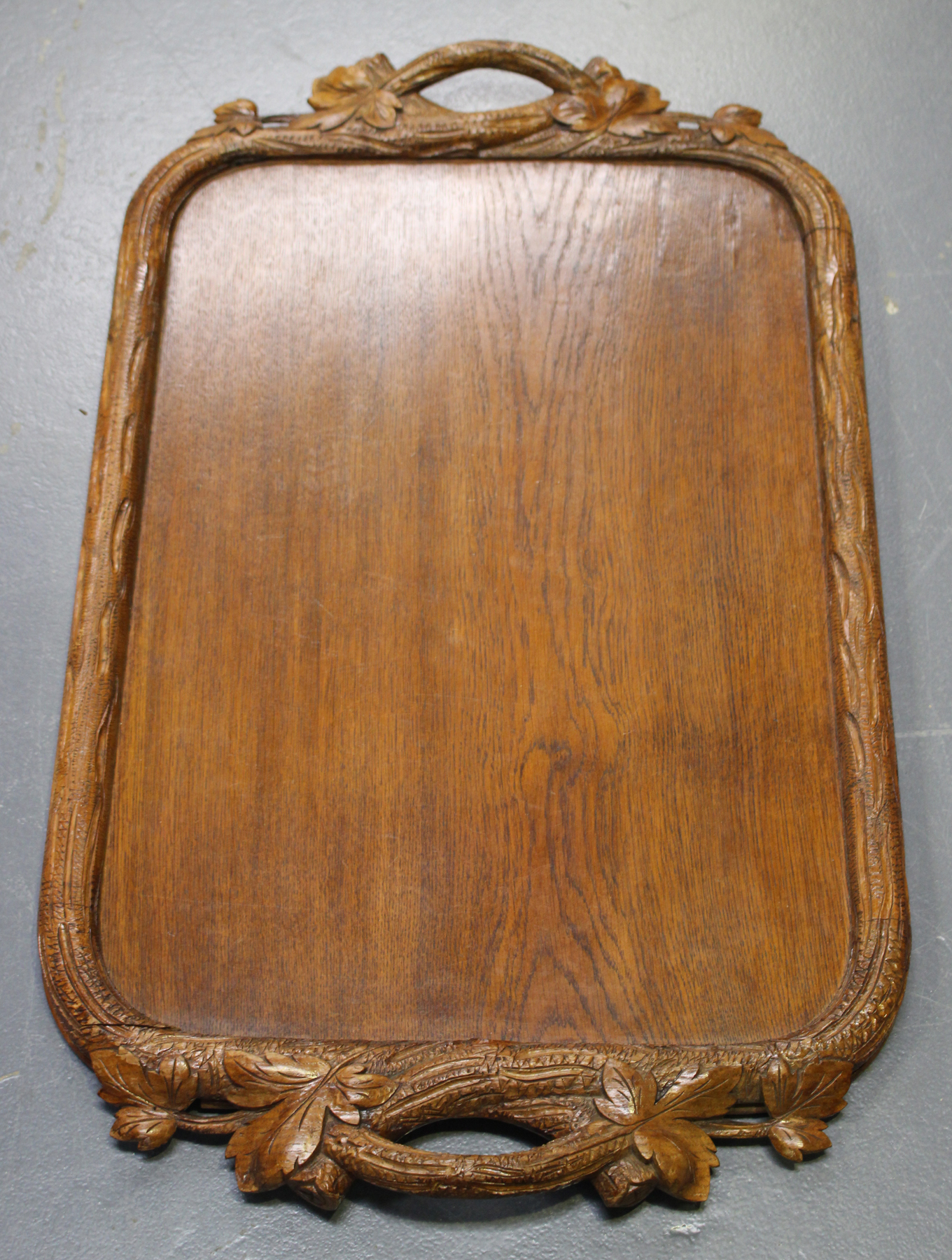 A mid-20th century Swiss Black Forest carved oak tea tray, the border naturalistically carved in the