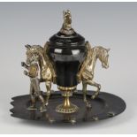 A late 19th century black patinated and gilt cast brass inkwell, modelled in the form of opposing