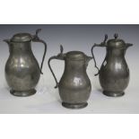 A group of three 19th century Continental pewter tappit lidded flagons of baluster form, all with