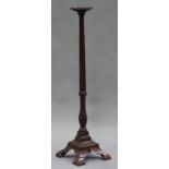 A 19th century mahogany bedpost torchère, the circular top raised on a turned and fluted column,