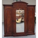 A good mid-Victorian mahogany breakfront wardrobe, the moulded pediment above a central mirrored