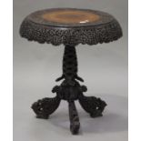 A late 19th/early 20th century Burmese carved hardwood wine table, the circular top with a pierced