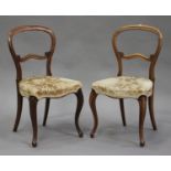 A set of six Victorian walnut balloon back dining chairs, the upholstered seats on cabriole legs,