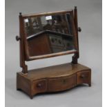 A George III mahogany swing frame mirror, the serpentine fronted base fitted with three drawers,