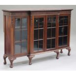 An early 20th century mahogany breakfront glazed bookcase, carved with a blind fretwork frieze,