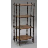 A Victorian walnut four-tier whatnot, the shaped shelves on turned supports with brass caps and