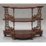 A mid-Victorian burr walnut three-tier whatnot, the serpentine front support by turned and pierced