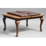 A George V mahogany extending dining table with two extra leaves, on cabriole legs and castors,