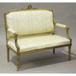 A late 19th century Louis XVI style giltwood and gesso salon settee with carved rose swagged