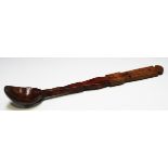 A 19th century Welsh yew wood long handled spoon with a shaped shaft and curved bowl, length 38.