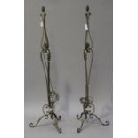 A pair of early/mid-20th century gilded wrought lamp standards with leaf mounts and scrolling