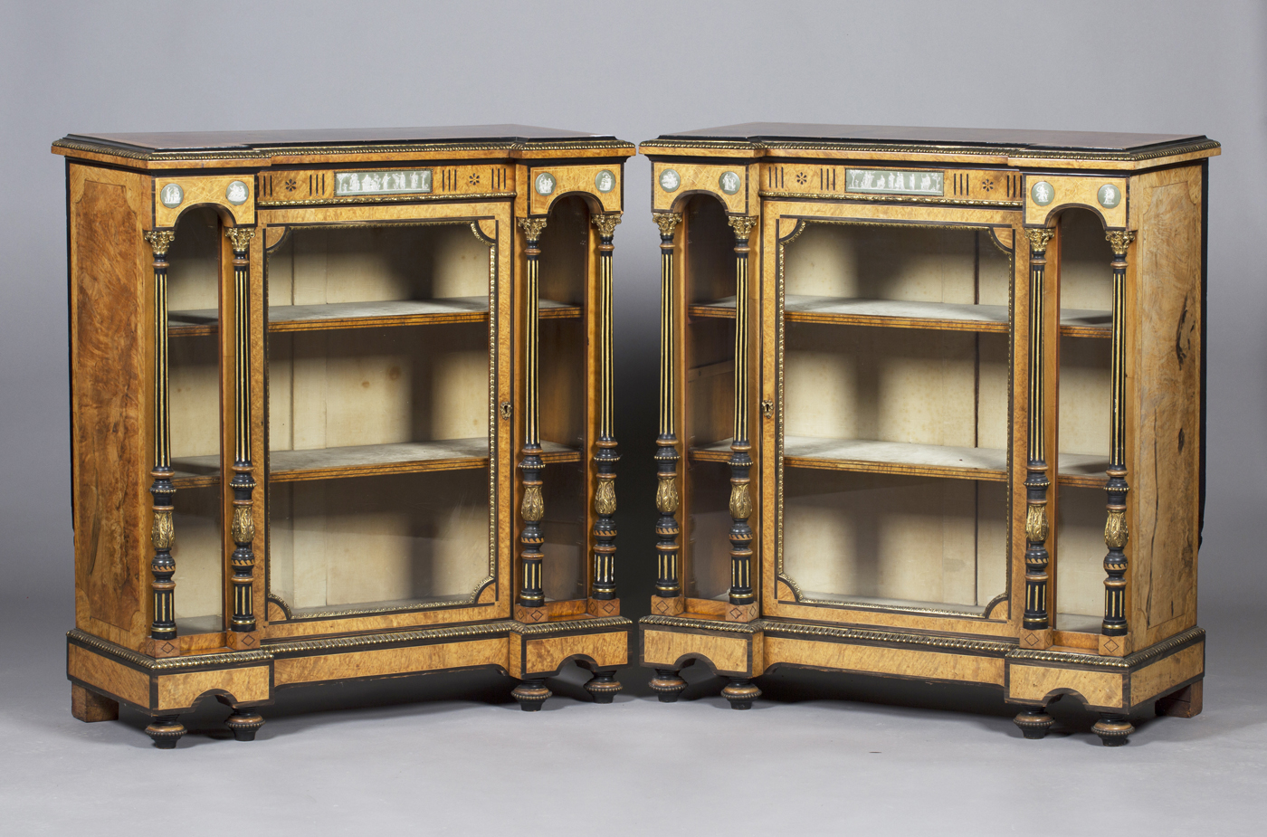 A pair of mid-Victorian burr walnut pier cabinets with ebony banding, each frieze inset with green