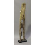 A modern driftwood sculpture, mounted on an ebonized stand, height 182cm.Buyer’s Premium 29.4% (
