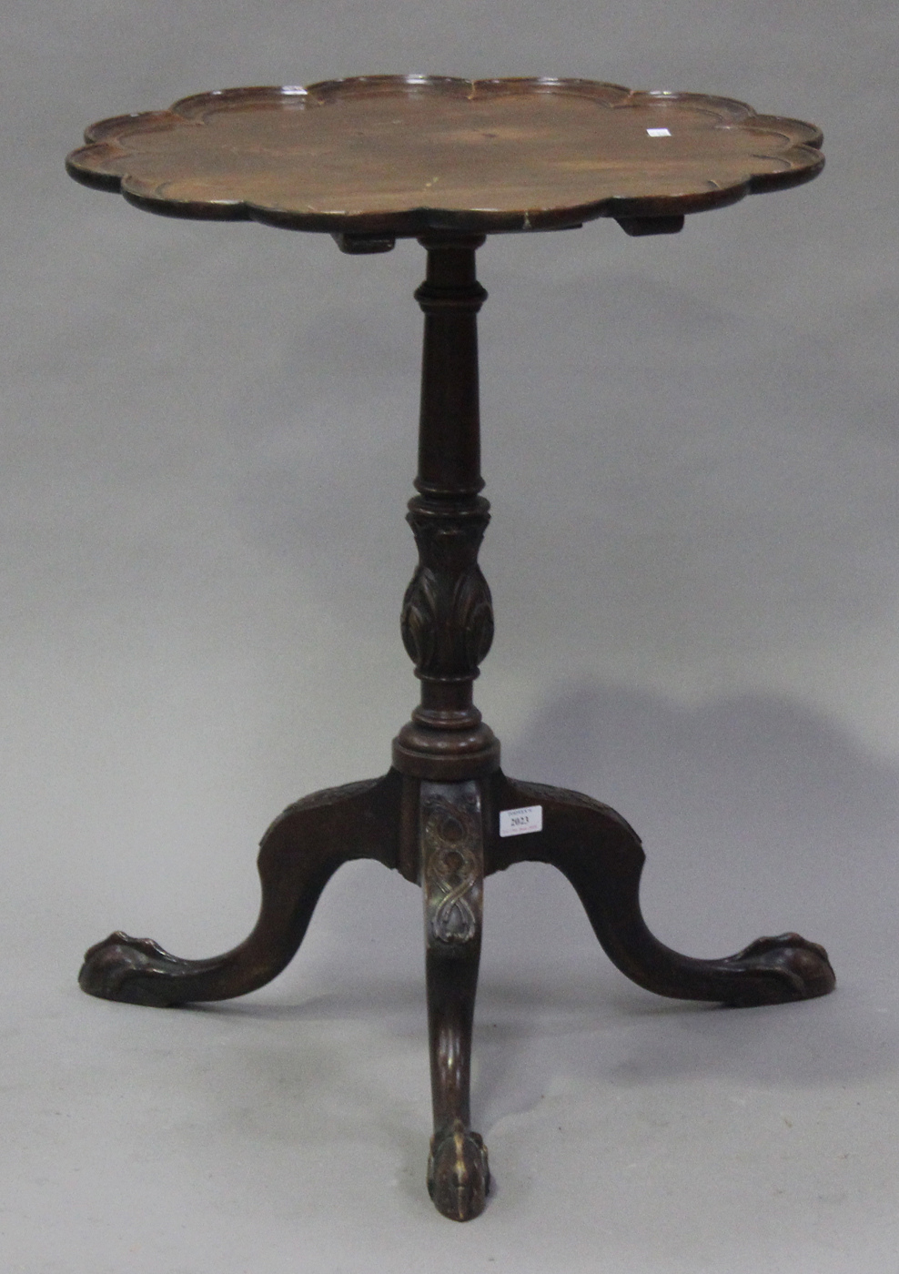 A late 19th century George III style mahogany wine table with shaped border, the turned column