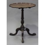 A late 19th century George III style mahogany wine table with shaped border, the turned column