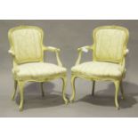 A pair of 19th century Louis XV style fauteuil armchairs, the cream painted and gilded frames carved