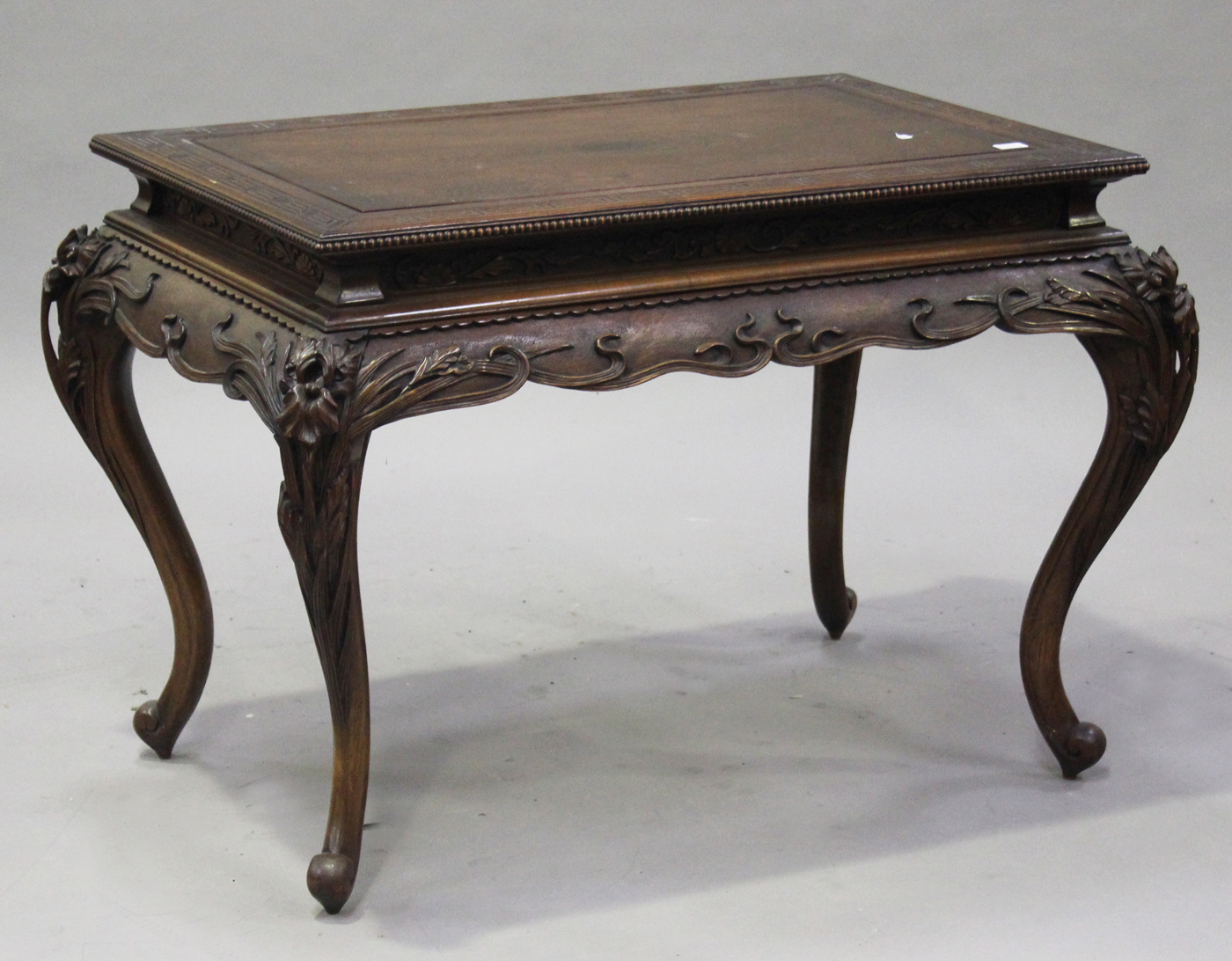 A Japanese Art Nouveau carved softwood centre table, the panelled top above a shaped frieze carved