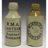 A large collection of approximately sixty-five stoneware ginger beer bottles, including an R.M.A