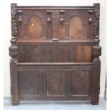 A 19th century Carolean Revival oak double bed frame, the panelled ends with carved and applied