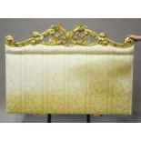 A mid-19th century carved giltwood and upholstered headboard, the shaped crest heavily carved with