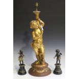 A 20th century gilded and coloured plaster figural table lamp with a putto column, raised on a