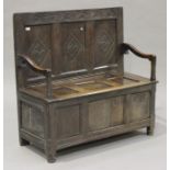 An 18th century oak panelled box seat settle with diamond and lunette carved decoration, the back