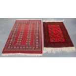 A Pakistan bokhara rug, mid-20th century, the red field with columns of guls, together with