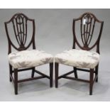 A pair of 19th century Sheraton style mahogany shield back dining chairs with carved decoration, the