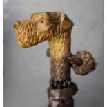 An early/mid-20th century parasol, the carved softwood handle modelled as a dog's head, length 57cm,