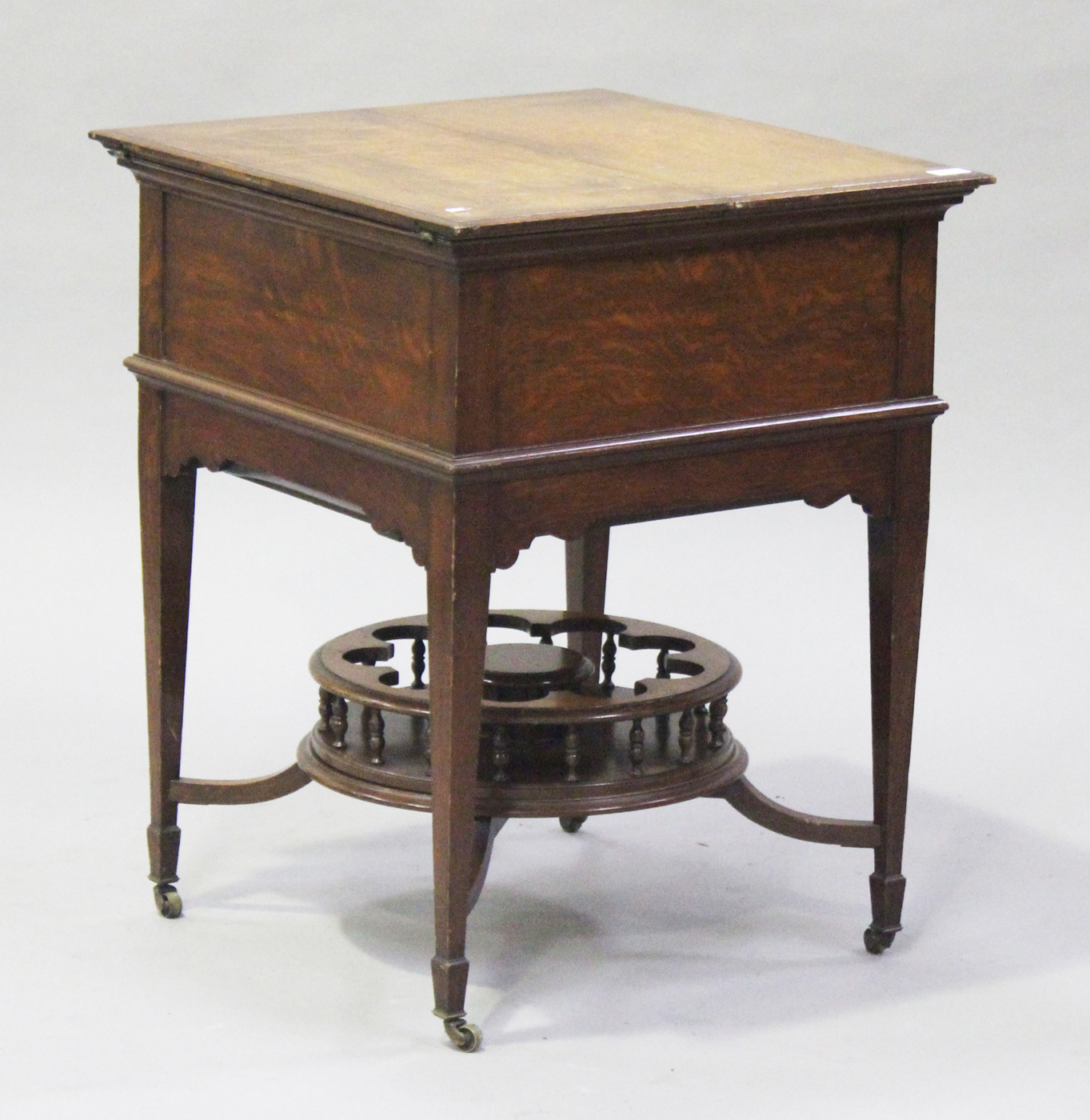 A George V oak metamorphic drinks cabinet, the double hinged top revealing a rising interior bearing