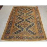 A Kurdish rug, early 20th century, the blue field with a column of stepped medallions, within a