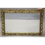 An early 20th century Florentine style carved giltwood framed wall mirror of foliate section, 92cm x