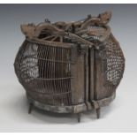 A 20th century South-east Asian carved wood and rattan bird cage of double-sided form, width 25cm.
