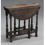 A 19th century oak circular gateleg table with turned and block legs united by stretchers, on scroll