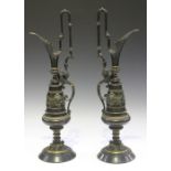 A pair of late 19th century brown and gilt patinated cast bronze ornamental ewers of neoclassical