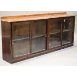 A Victorian and later stained pine bookcase cabinet, fitted with four sliding glass doors, on a