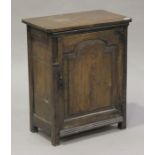 A 19th century oak cupboard, fitted with an arched panel door revealing a shelf, on stile