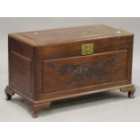 An early 20th century Chinese camphor trunk with carved decoration and hinged lid, on bracket