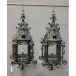 A pair of early 20th century wrought iron cylindrical hanging lanterns, the conical tops and sides