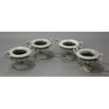 A set of four late 19th century painted cast iron urns of squat campana form with scroll handles,