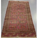 A Saryk rug, Turkestan, early 20th century, the plum field with two columns of seven guls, within