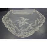 An early 20th century Brussels lace wedding veil of shaped form, decorated with leaves and flower