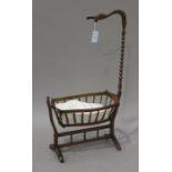 An early 19th century French walnut framed doll's crib, the canopy support modelled as a swan's