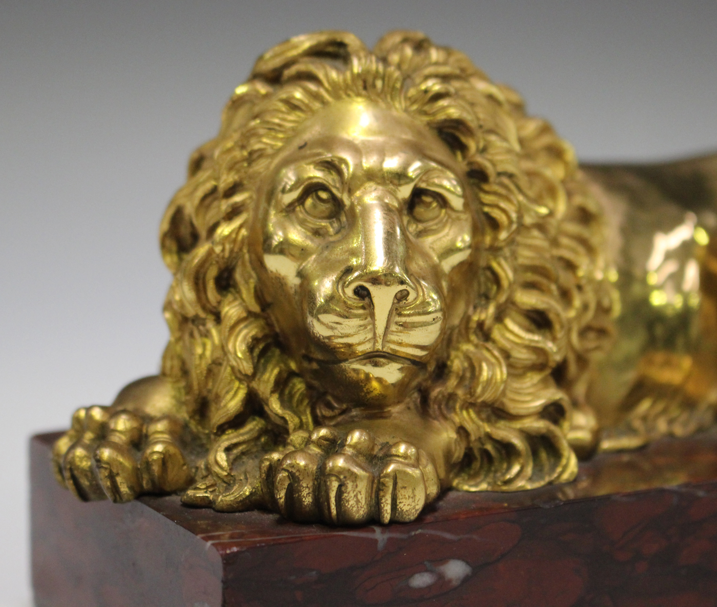 A late 19th/early 20th century gilded cast bronze model of a recumbent lion, on a rose marble - Image 3 of 4