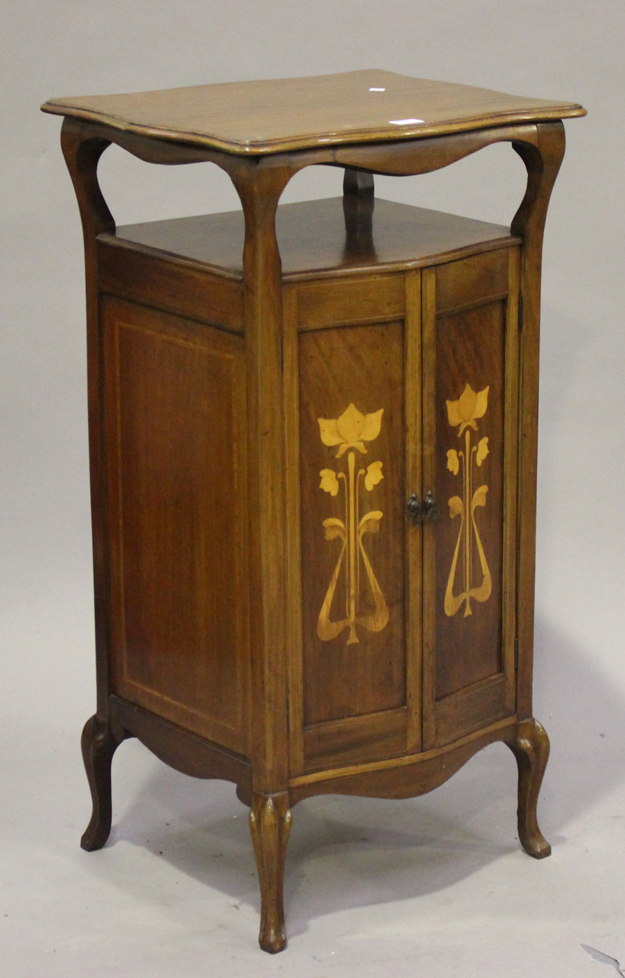 An Edwardian Art Nouveau mahogany side cabinet, in the manner of Liberty & Co, the serpentine shaped
