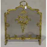 A late 19th/early 20th century Rococo Revival gilt metal firescreen with leaf and flower scroll